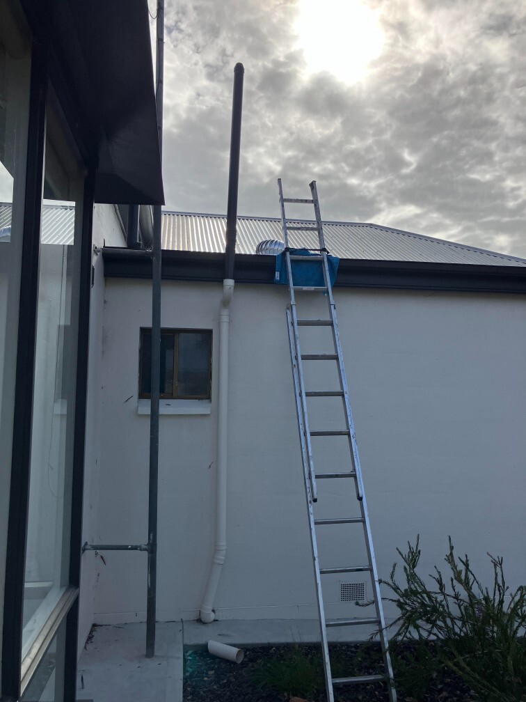 Roof turbine vent installation on corrugated metal roof using ladder access