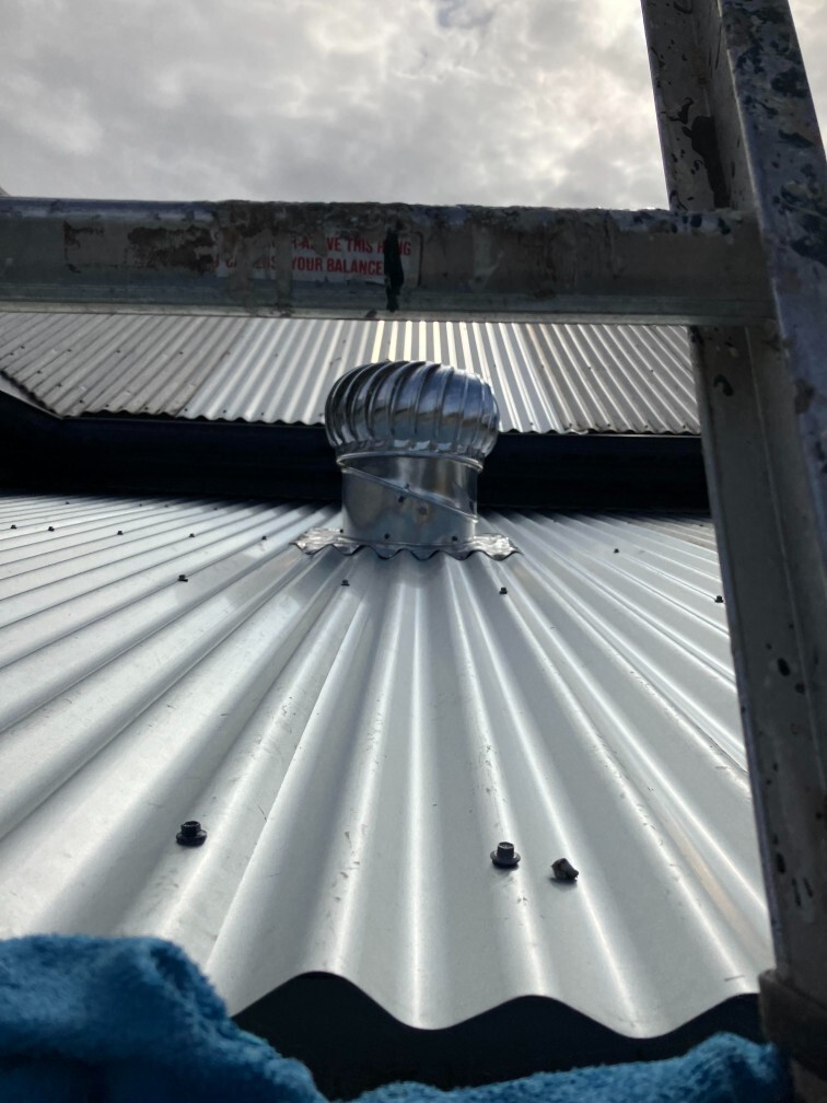 Turbine roof vent installed on corrugated metal roofing for attic ventilation