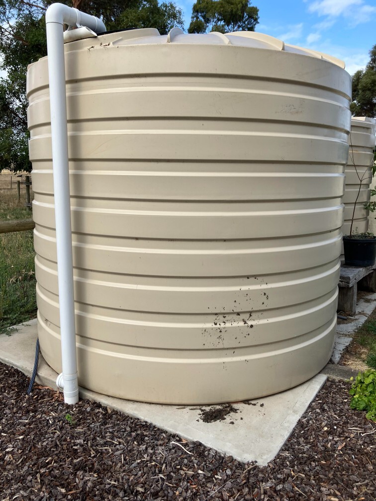 Large residential rainwater tank connected to downpipe for roof water collection